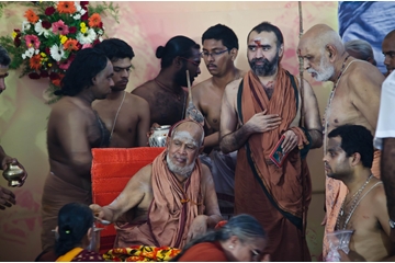 His Holiness giving teerthaprasadam to devotees